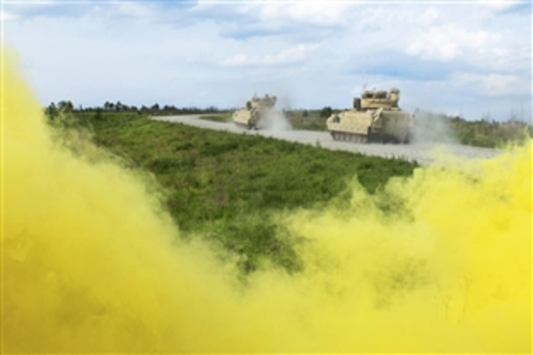 M2 Bradley Fighting Vehicles advance under the cover of smoke to their next objective during a combined arms live-fire exercise on Fort Benning, Ga., May 14, 2015. 