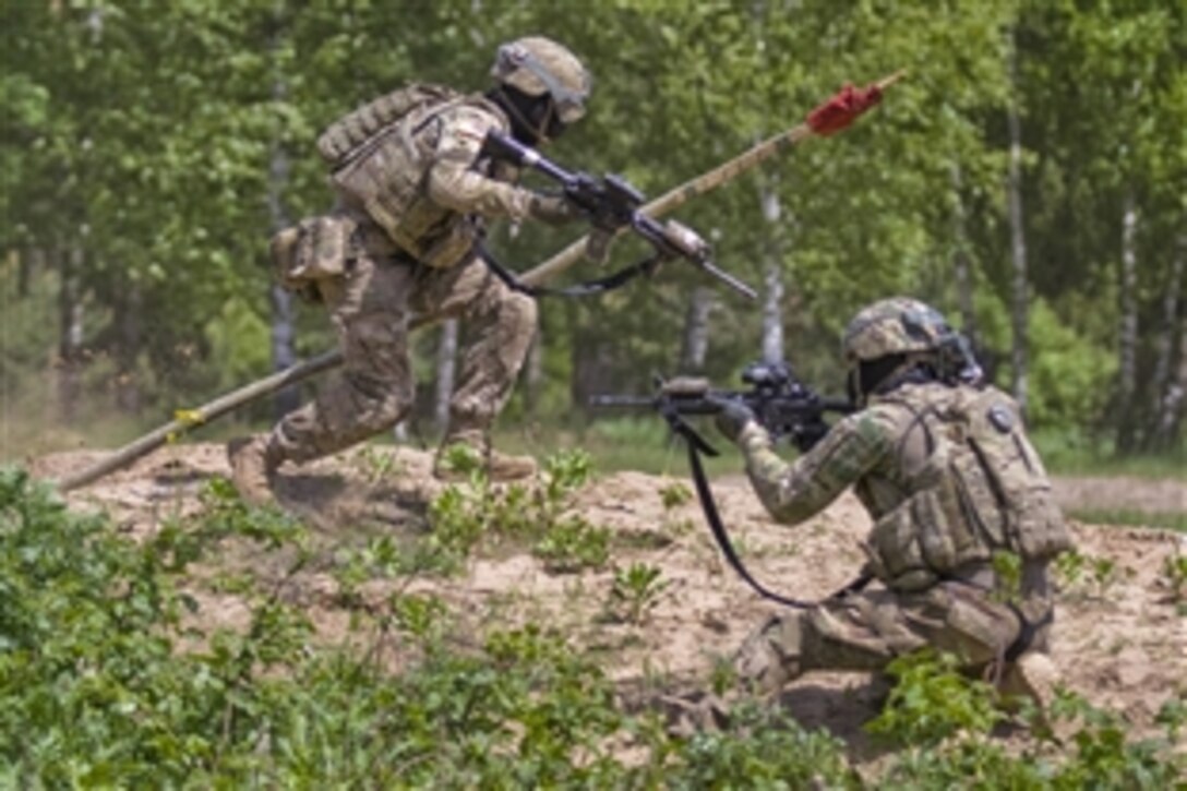 U.S. Army Spc. Edgar, Pinpena, left, sprints back to his base with the opposing team’s flag while Spc. Jesse Bray covers his retreat during a force-on-force competition with Lithuanian partners at the Great Lithuanian Hetman Jonusas Radvila Training Regiment in Rukla, Lithuania, May 28, 2015. The U.S. soldiers are part of Operation Atlantic Resolve, an ongoing multinational partnership focused on joint training and security cooperation between the United States and other NATO allies.