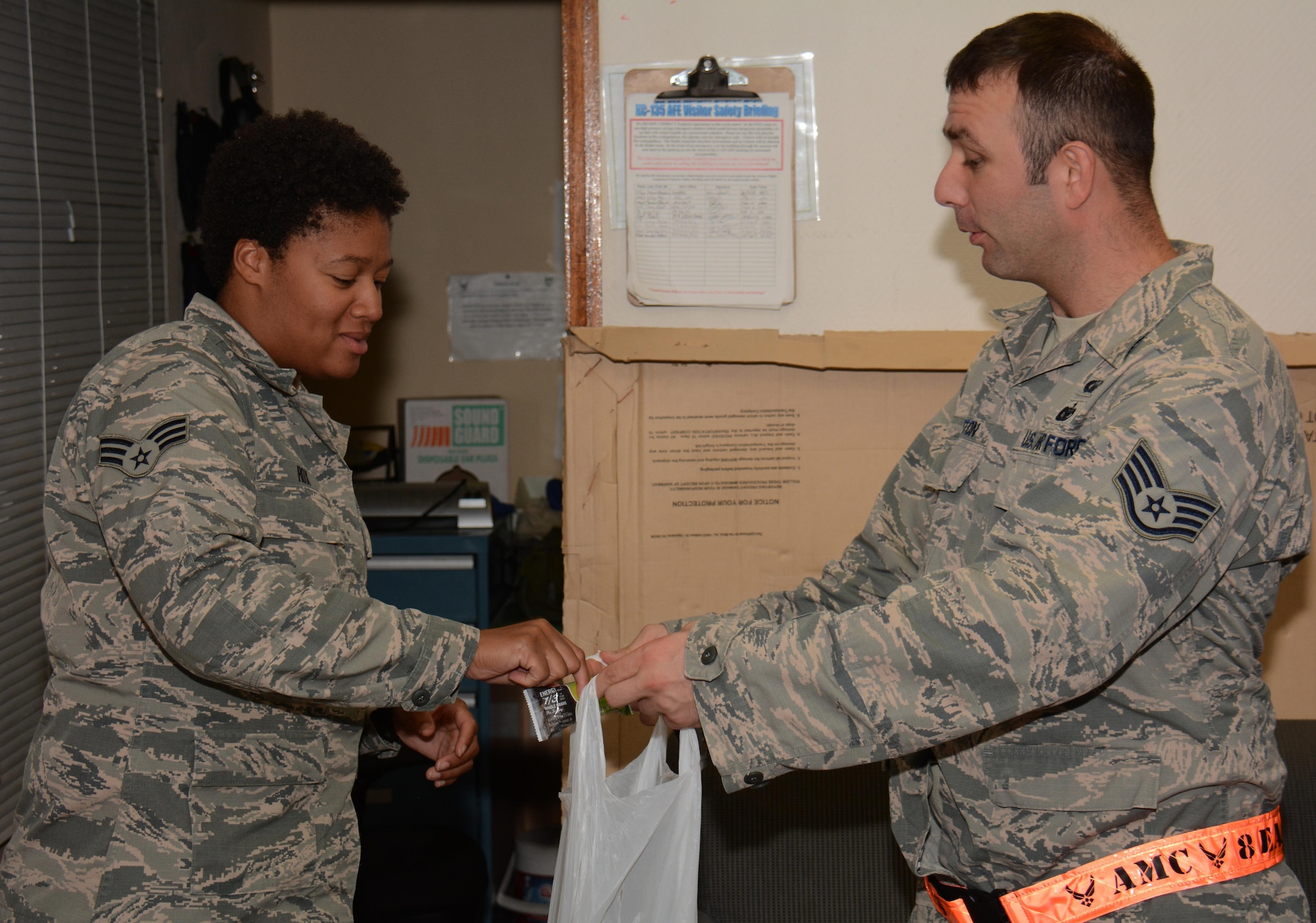 Staff Sgt. Jeremy Horton, 379th Air Expeditionary Wing chaplain's assistant, asks Senior Airman Leslie Rox, 379th Expeditionary Operations Support Squadron aircrew flight equipment technician, to take something from his bag of goodies at Al Udeid Air Base, Qatar Oct. 31 during a chaplain led Blitz Program visit. The program focuses on visiting shift workers and informing those airmen of the resources available to them. More than 20 professionals took part in the Halloween visit with 379th Expeditionary Operations Group airmen. (U.S. Air Force photo by Tech. Sgt. James Hodgman)