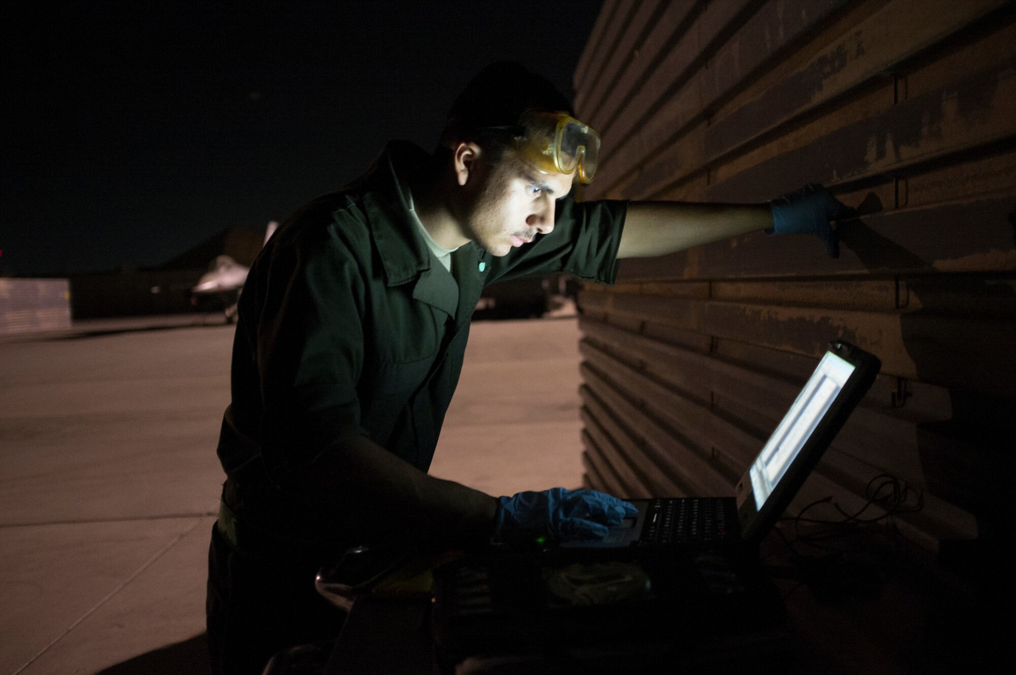 Senior Airman David Campeau, 455th Expeditionary Aircraft Maintenance Squadron assistant dedicated crew chief, reviews a technical order on an e-Tool prior to performing servicing operations on his assigned F-16 Fighting Falcon at Bagram Airfield, Afghanistan, Sept. 13, 2015.  The F-16 is a multi-role fighter aircraft that is highly maneuverable and has proven itself in air-to-air and air-to-ground combat.  (U.S. Air Force photo by Master Sgt. Kevin Crawford/Released)