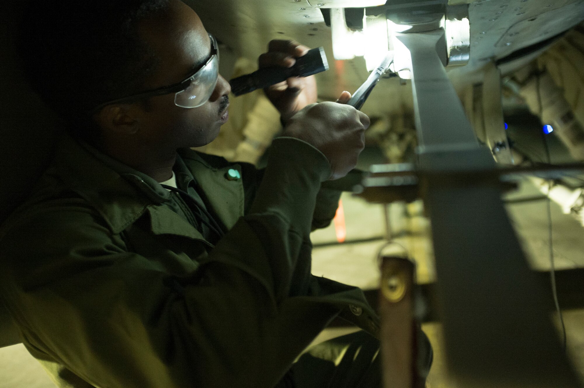 Senior Airman Loring Loney, 455th Expeditionary Aircraft Maintenance Squadron assistant dedicated crew chief, safety wires the shear bolt on the F-16 Fighting Falcon's arresting hook after disconnecting the hold-back assembly from the aircraft tie-down on the trim pad at Bagram Airfield, Afghanistan, Sept. 16, 2015. The F-16 is a multi-role fighter aircraft that is highly maneuverable and has proven itself in air-to-air and air-to-ground combat.  (U.S. Air Force photo by Master Sgt. Kevin Crawford/Released)