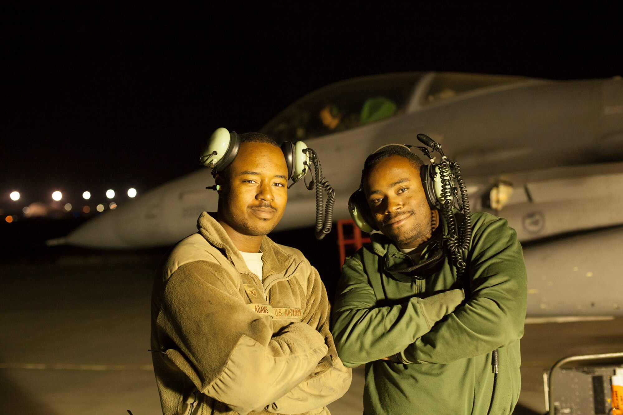 Senior Airman Anthony Adams, left, and Senior Airman Steven Pierce both electrics and environmental system specialists assigned to the 455th Expeditionary Aircraft Maintenance Squadron, pose for a photo prior to troubleshooting the F-16 Fighting Falcon's environmental control system during a high power maintenance engine run on the trim pad at Bagram Airfield, Afghanistan, Sept. 17, 2015.  The F-16 is a multi-role fighter aircraft that is highly maneuverable and has proven itself in air-to-air and air-to-ground combat.  (U.S. Air Force photo by Master Sgt. Kevin Crawford/Released)
