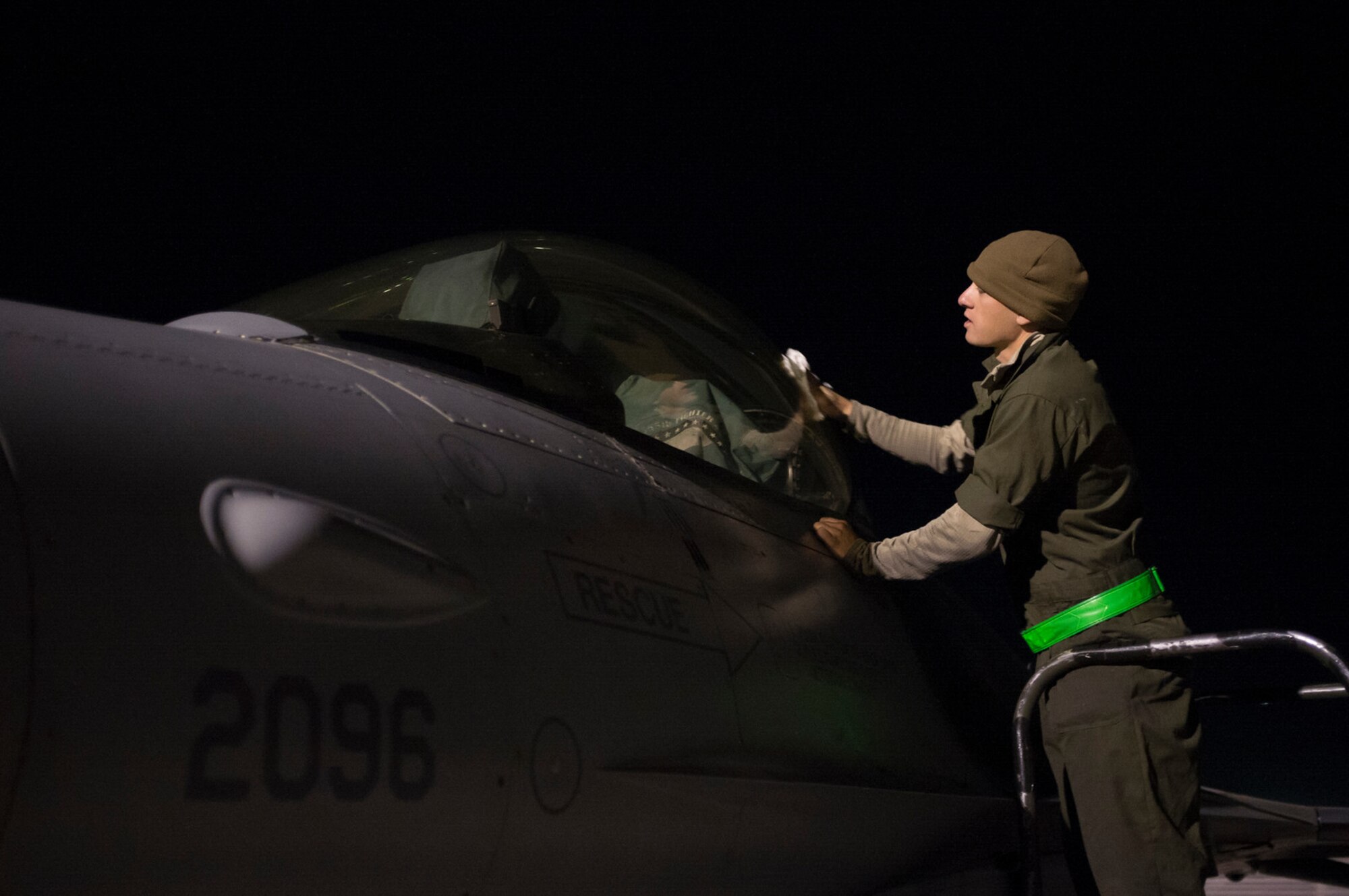 Senior Airman Andrew Burke, 455th Expeditionary Aircraft Maintenance Squadron assistant dedicated crew chief, cleans the canopy of his assigned F-16 Fighting Falcon prior to an air tasking order combat mission at Bagram Airfield, Afghanistan, Sept. 24, 2015. The F-16 is a multi-role fighter aircraft that is highly maneuverable and has proven itself in air-to-air and air-to-ground combat.  (U.S. Air Force photo by Master Sgt. Kevin Crawford/Released)