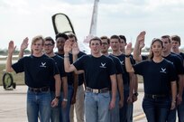 Air Force recruits recite the oath of enlistment at Joint Base San Antonio-Randolph Oct. 31, 2015. The enlistment was held before the U.S. Thunderbirds performance at the 2015 JBSA Air Show & Open House at JBSA-Randolph. In attendance were friends and family who witnessed the enlistment.(U.S. Air Force photo by photo by Johnny Saldivar)