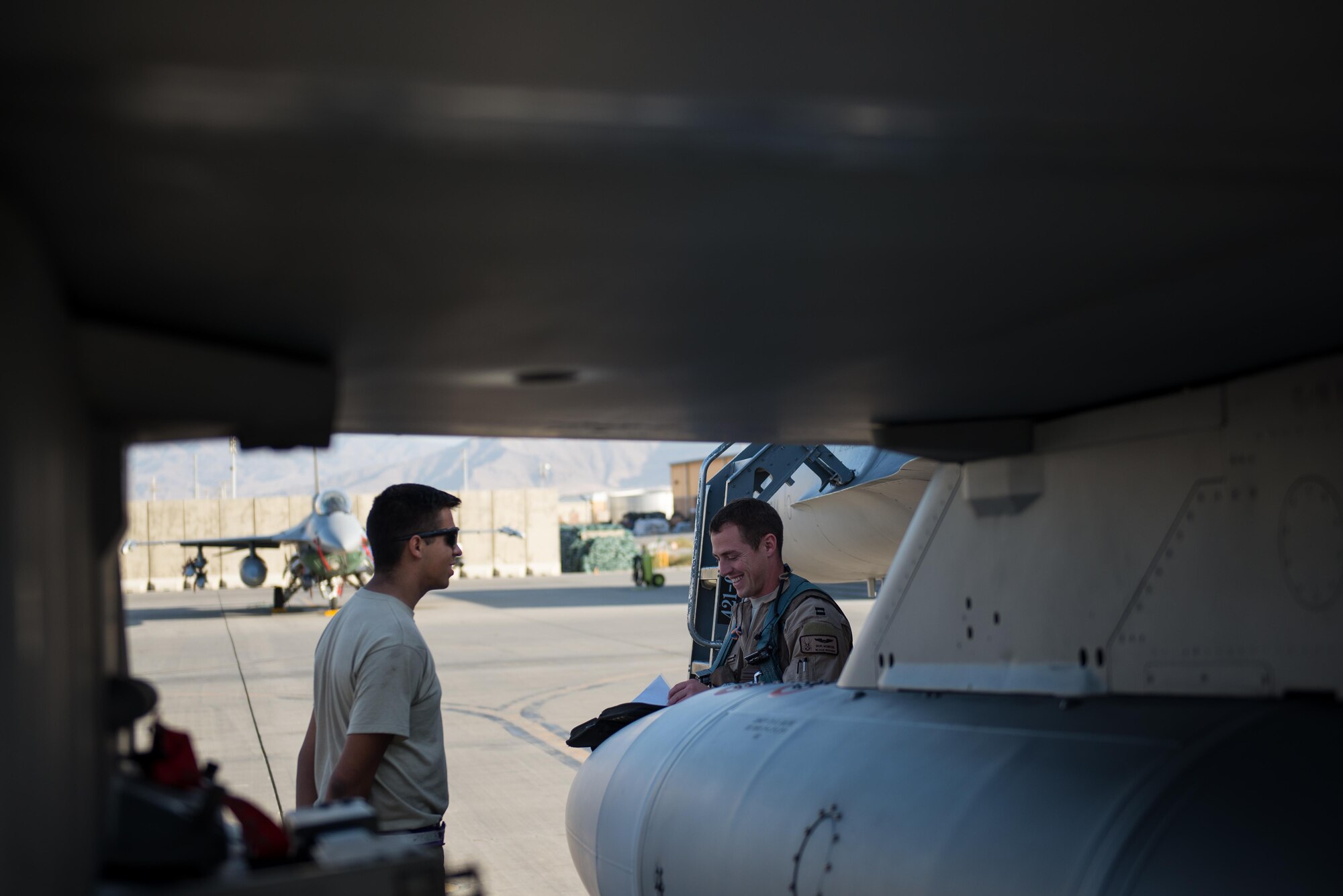 Capt. Tyler McBride, right, 421st Expeditionary Fighter Squadron chief of safety, deployed from Hill Air Force Base, Utah, goes over pre-flight paperwork with Airman 1st Class Christian Lamb, 455th Expeditionary Aircraft Maintenance Squadron crew chief, deployed from Aviano Air Base, Italy, at Bagram Airfield, Afghanistan, Oct. 30, 2015. The 555th EFS, deployed from Aviano Air Base, Italy, is nearing the end of its six-month deployment at Bagram and will hand the reins over to the 421st EFS in support of Operation Freedom's Sentinel and NATO's Resolute Support mission. (U.S. Air Force photo by Tech. Sgt. Joseph Swafford/Released)