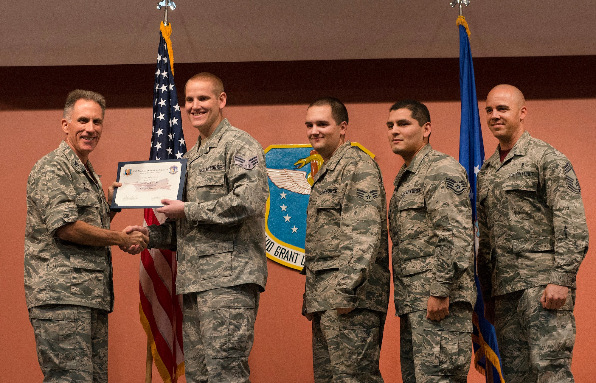 Col. Michael Ross, the 60th Medical Operations Squadron commander, presents Airman 1st Class Spencer Stone, a 60th Medical Operations Squadron medical technician, with a promotion certificate. Stone was promoted to senior airman at Travis Air Force Base, Calif., Oct. 30, 2015. Senior Airman Benjamin Kovacevic, Staff Sgt. Roberto Davila, and Chief Master Sgt. Oren Sieff, all from the 60th Medical Group, tacked on Stone's new stripes during a group promotion ceremony at David Grant U.S. Air Force Medical Center. Following his promotion, Stone was promoted to the rank of staff sergeant, effective Nov. 1, by order of Air Force Chief of Staff Gen. Mark A. Welsh III. According to Air Force Instruction 36-502, the chief of staff of the Air Force has the authority to promote any enlisted member to the next higher grade. (U.S. Air Force photo/T.C. Perkins Jr.)
