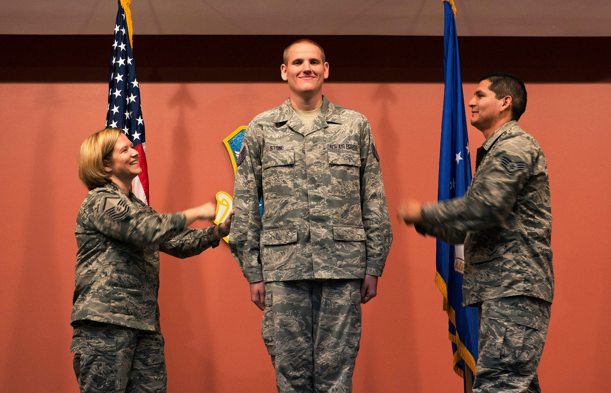 Master Sgt. Tanya Hubbard and Staff Sgt. Roberto Davila, both assigned to the 60th Medical Group, tack staff sergeant stripes onto Spencer Stone, a 60th Medical Operations Squadron medical technician, during a promotion ceremony at Travis Air Force Base, Calif., Oct. 30, 2015. Stone was promoted to the rank of staff sergeant, effective Nov. 1, by order of Air Force Chief of Staff Gen. Mark A. Welsh III. Stone was promoted to staff sergeant for the leadership and courage he showed in August when he and two friends thwarted a potential terrorist attack on a train traveling to Paris. (U.S. Air Force photo/T.C. Perkins Jr.)