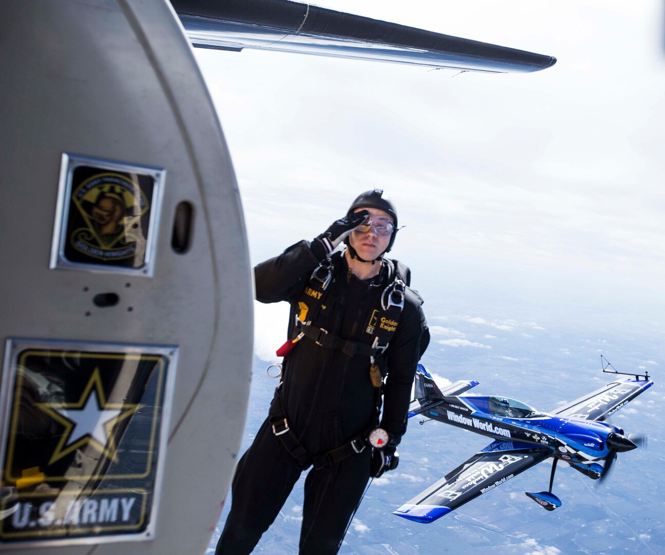 Staff Sergeant Roman Grijalva, U.S. Army Golden Knights demonstration team parachutist, salutes as he jumps into the air during their routine Oct. 31 at the 2015 Joint Base San Antonio Air Show and Open House at JBSA-Randolph. Air shows allow the Air Force and sister services to display the capabilities of military aircraft and members to the American taxpayer through aerial demonstrations and static displays.