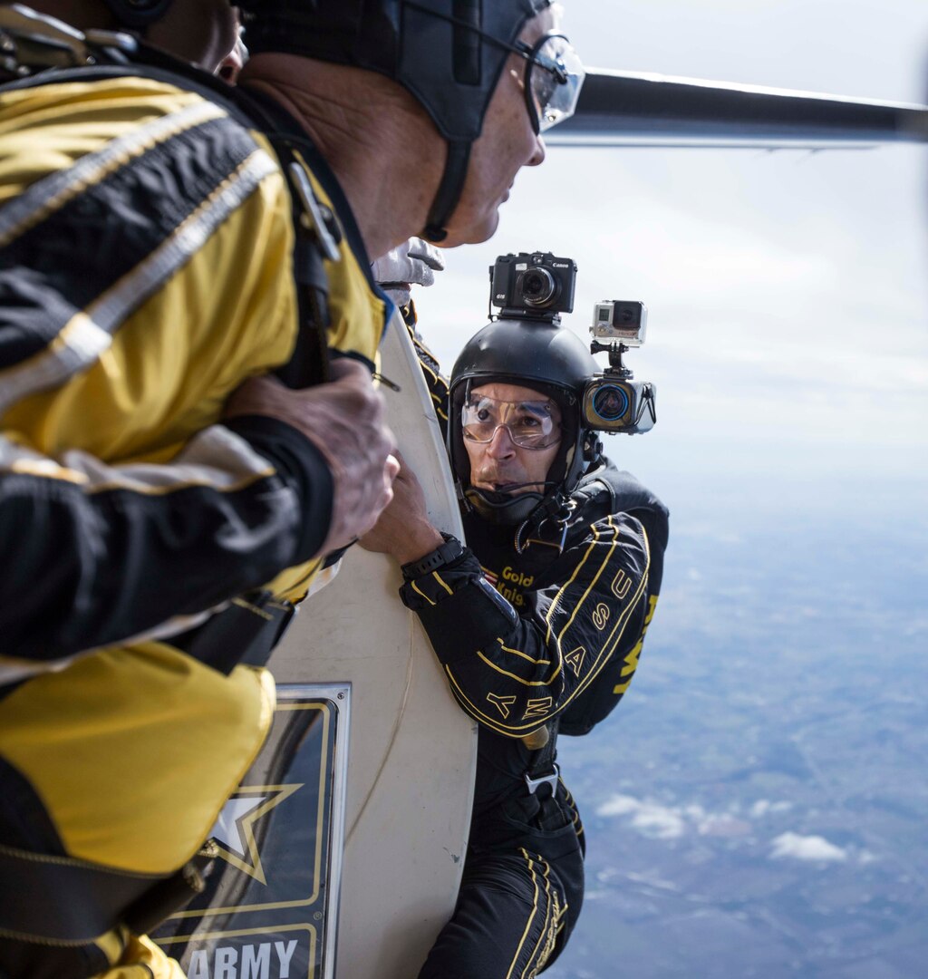 Staff Sgt. Jonathon Lopez, U.S. Army Golden Knights demonstration team tandem jump cameraman, prepares to jump with a fellow parachutist and tandem jumper exiting the aircraft during the team’s routine Oct. 31 during the 2015 Joint Base San Antonio Air Show and Open House at JBSA-Randolph. The Golden Knights have a threefold mission: recruit the next generation of Soldiers, support public outreach through conducting tandem parachute jumps and compete against the world’s best skydivers at national and international parachuting competitions.