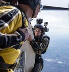 Staff Sgt. Jonathon Lopez, U.S. Army Golden Knights demonstration team tandem jump cameraman, prepares to jump with a fellow parachutist and tandem jumper exiting the aircraft during the team’s routine Oct. 31 during the 2015 Joint Base San Antonio Air Show and Open House at JBSA-Randolph. The Golden Knights have a threefold mission: recruit the next generation of Soldiers, support public outreach through conducting tandem parachute jumps and compete against the world’s best skydivers at national and international parachuting competitions.