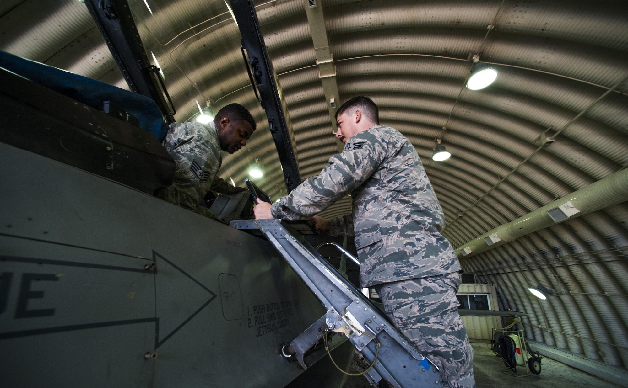 Staff Sgt. Angelo Lowe and Senior Airman James Glass, both 8th Maintenance Squadron egress systems technicians, perform an inspection on the landing gear of an F-16 Fighting falcon at Kunsan Air Base, Republic of Korea, Oct. 29, 2015.  The ejection system is a pilot’s only chance at survival if all other means fail to correct an aircraft malfunction. (U.S. Air Force photo by Staff Sgt. Nick Wilson/Released) 