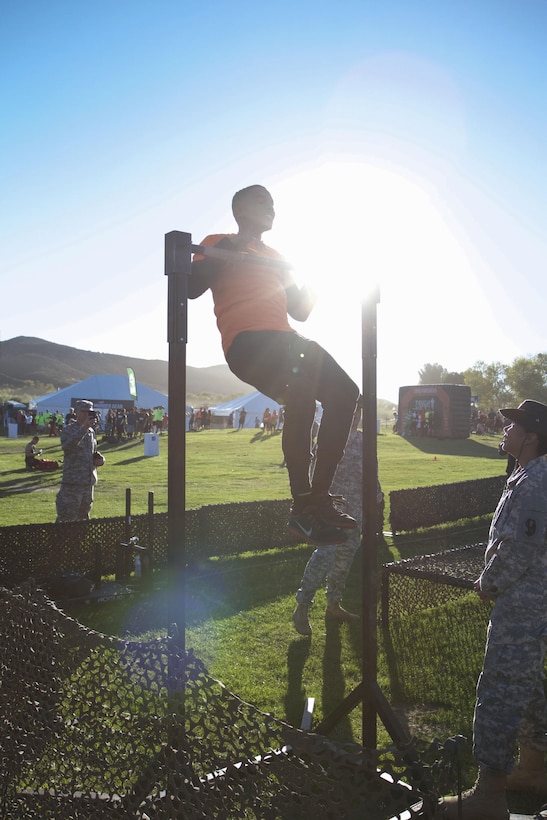 Ray Duffy, a massage therapist student from Oceanside, Calif., challenges himself at the Army Reserve challenge flanked by drill sergeants from 2nd Battalion, 413th Regiment, 95th Training Division at the 2015 Southern California Tough Mudder race in Temecula Oct. 31. The U.S. Army Reserve was a sponsor of the Tough Mudder this year, which meant Reserve Soldiers spotted, motivated and assisted racers at the obstacles. Duffy said he wanted to try the challenge (pushing a weighted sled, five pullups, low crawl, 20 pushups, and pulling the weighted sled back into place), because it looked like fun and he’s a supporter of the U.S. Army. (Photo by Sgt. 1st Class Alexandra Hays, 201st Press Camp Headquarters)