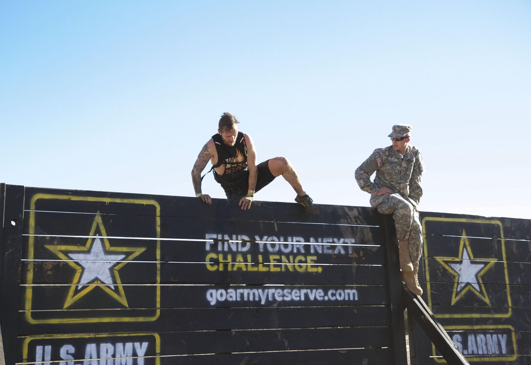 A competitor at the 2015 Southern California Tough Mudder in Temecula, Calif., Oct. 31, 2015, attempts the “Berlin Wall,” one of the 21 obstacles in this year’s event, flanked by Pfc. Dane E. Shoebotham, a combat engineer with the 305th Engineering Battalion out of Camp Pendleton, Calif. The U.S. Army Reserve was a sponsor of the Tough Mudder this year, which meant Reserve Soldiers spotted, motivated and assisted racers at the obstacles. (Photo by Sgt. 1st Class Alexandra Hays, 201st Press Camp Headquarters)