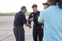 The U.S. Golden Knights Sgt. Alex Bahry hands a baton to Dr. Eugene Derricotte, Documented Original Tuskegee Airman during the 2015 Air Show and Open House Nov. 1, 2015 at Joint Base San Antonio-Randolph, Texas. Air shows allow the Air Force to display the capabilities of our aircraft to the American taxpayer through aerial demonstrations and static displays and allowing attendees to get up close and personal to see some of the equipment and aircraft used by the U.S. military today. (U.S. Air Force photo by Olivia Mendoza) 