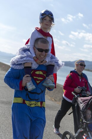 A family races to the finish line during a Superhero Fun Run on the Seawall at Marine Corps Air Station Iwakuni, Japan, Oct. 31, 2015. The 1.5K run allowed station residents to celebrate the Halloween festivities while being physically active. Snacks and beverages waited at the finish line as participants crossed. Once bellies were filled, families had the opportunity to take their photos with an outline of a comic-style city backdrop.