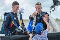 Cadet Dylan Smith and Cadet Dennis Cook from the U.S. Air Force Academy's Wings of Blue parachute team high fives Ricardo Silva from San Antonio, Texas, during the opening ceremonies of the 2015 Joint Base San Antonio Air Show and Open House Nov. 1. Air shows allow the Air Force to display the capabilities of our aircraft to the American taxpayer through aerial demonstrations and static displays. JBSA-Randolph’s air show allowed attendees to get up close and personal to see some of the equipment and aircraft used by the U.S. military today. (U.S. Air Force photo by Joshua Rodriguez/Released)