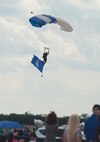 A member of the U.S. Air Force Wings of Blue lands with the U.S. Air Force flag during the opening ceremony at the 2015 Joint Base San Antonio Air Show and Open House Nov. 1, 2015, at JBSA-Randolph, Texas.  Air shows allow the Air Force to display the capabilities of our aircraft to the American taxpayer through aerial demonstrations and static displays. JBSA-Randolph’s air show allowed attendees to get up close and personal to see some of the equipment and aircraft used by the U.S. military today.  (U.S. Air Force photo by Senior Airman Krystal Wright/Released)