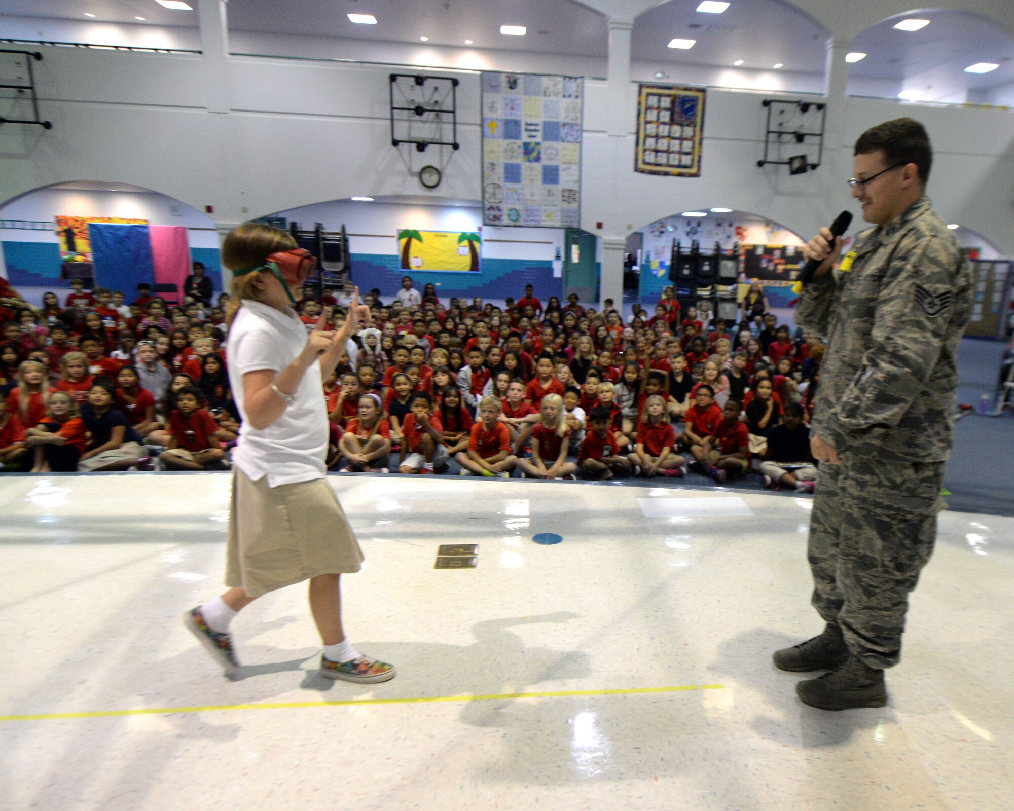 Staff Sgt. Christian Hills, 36th Medical Operations Squadron Alcohol and Drug Abuse Prevention and Treatment Program coordinator, watches a child walk a line while wearing impaired vision goggles, which simulate being intoxicated, during a Red Ribbon Week presentation Oct. 28, 2015, at Andersen Air Force Base, Guam. The presentations showed what drug abuse is and how to prevent it as well as including demonstrations from the military working dogs and ADAPT. (U.S. Air Force photo by Airman 1st Class Alexa Ann Henderson/Released)