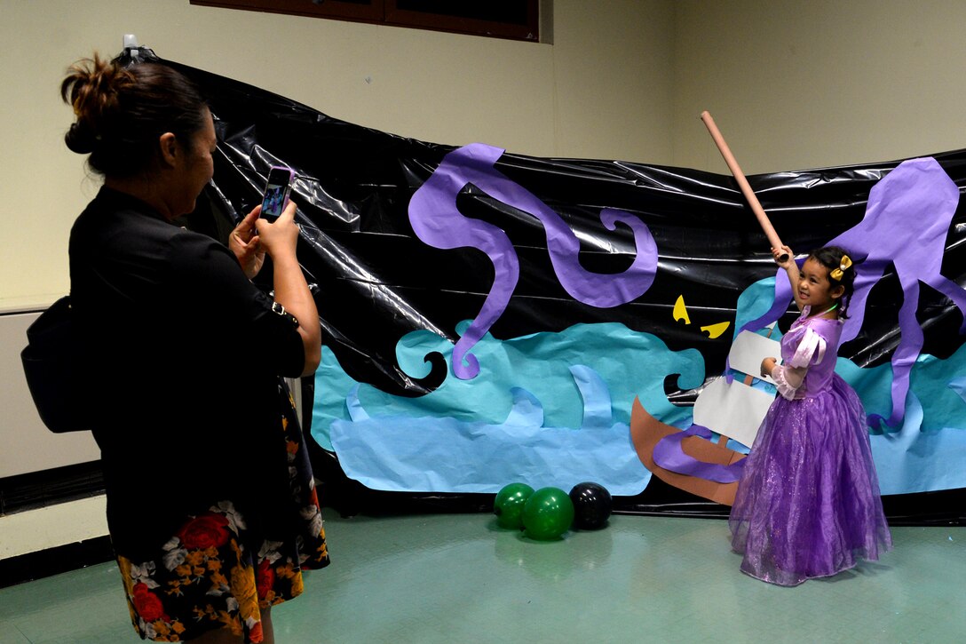 An Andersen family member poses for a picture at the  Trunk or Treat event held at Chapel 1 Oct. 30, 2015, at Andersen Air Force Base, Guam. The event included volunteers bringing decorated vehicles to a parking lot and passing out candy along with Halloween games and festivities inside the annex. (U.S. Air Force photo by Airman 1st Class Alexa Ann Henderson/Released)