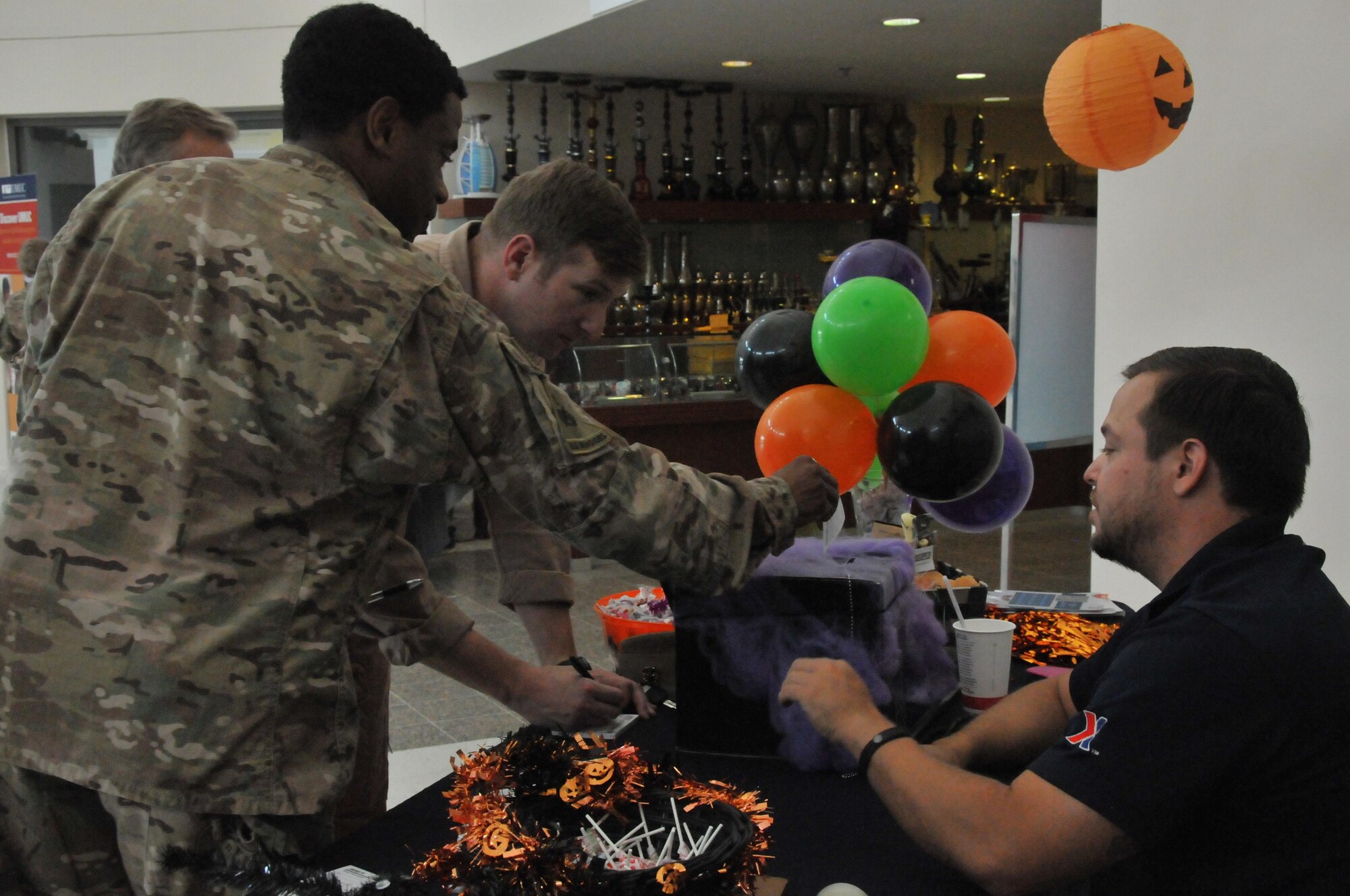 Service members sign up for a drawing sponsored by the Base Exchange at Al Udeid Air Base, Qatar Oct. 31. Prizes for the drawing consist of gift cards, gift baskets, movie tickets or a free month of internet. The grand prize was a winner’s choice of either a TV or game console. The Halloween bazaar located in the community center hosts a variety of venders. (U.S. Air Force photo by Tech. Sgt. Terrica Y. Jones/Released)