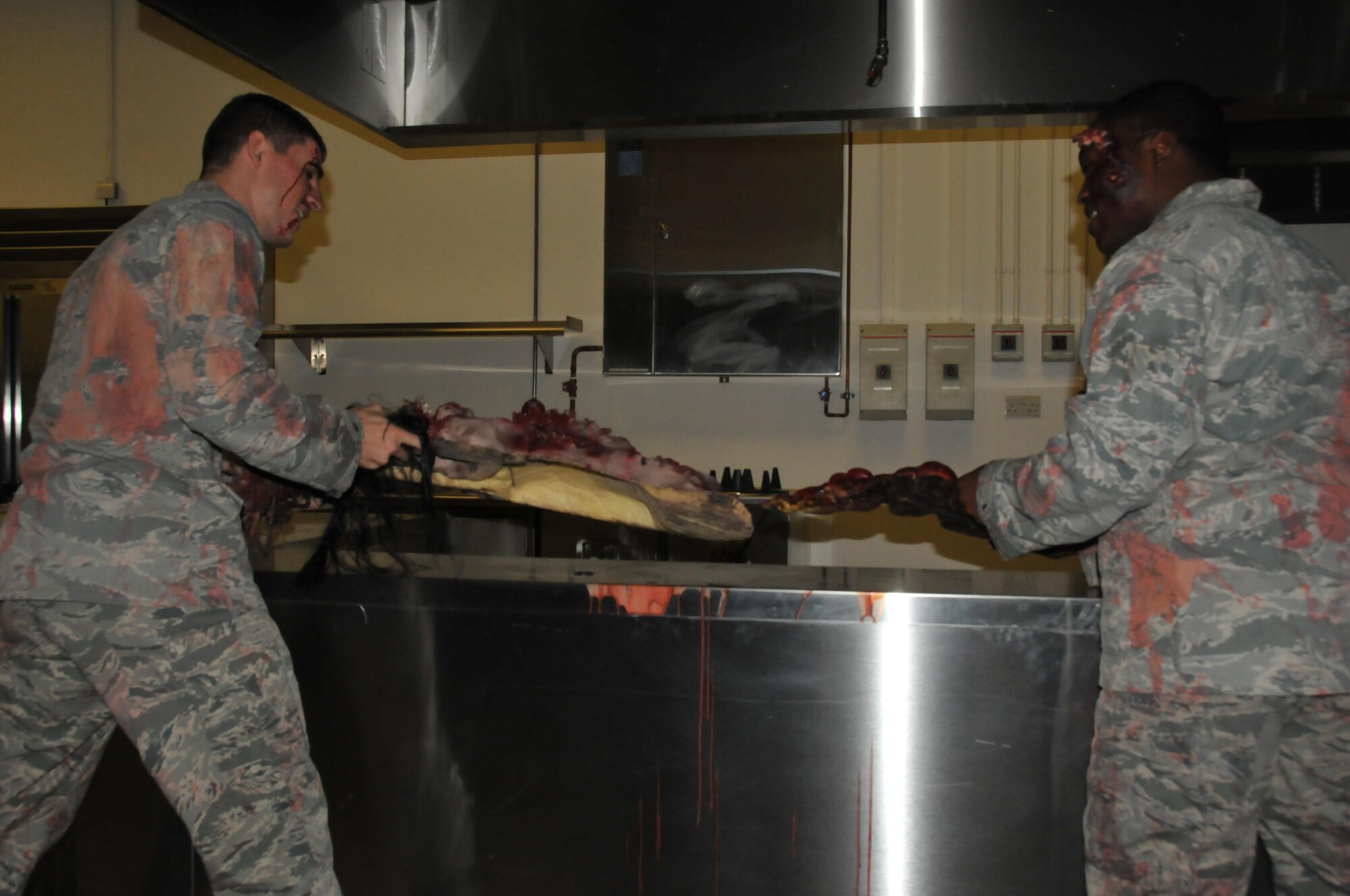 The 379th Expeditionary Logistic Readiness Squadron hosts a haunted house Oct. 30 at Al Udeid Air Base, Qatar. Airmen dressed as zombies station themselves in the haunted house preparing to give those who dare to enter a scare. This pre-Halloween activity gave airmen a taste of home. Airman 1st Class Bradley Agner and Airman 1st Class Andre Cargill tussle over a corpse in the haunted house. (U.S. Air Force photo by Tech. Sgt. Terrica Y. Jones/Released)