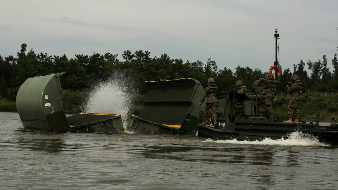 Marines open a component of an Improved Ribbon Bridge in the Central Training Area, Okinawa, Japan, during Blue Chromite 2016, Nov. 2, 2015. This was the first time that Improved Ribbon Bridges, flat modular-floating platforms that bridge wet gaps, were inserted by air on Okinawa. Blue Chromite is a large-scale amphibious exercise that draws primarily from III Marine Expeditionary Force’s training resources on Okinawa. The location of the training allows participating units to maintain a forward-deployed posture and eliminates the cost of traveling to train. The Marines are with 9th Engineer Support Battalion, 3rd Marine Logistics Group, III Marine Expeditionary Force. (U.S. Marine Corps photo by Cpl. Drew Tech/Released)