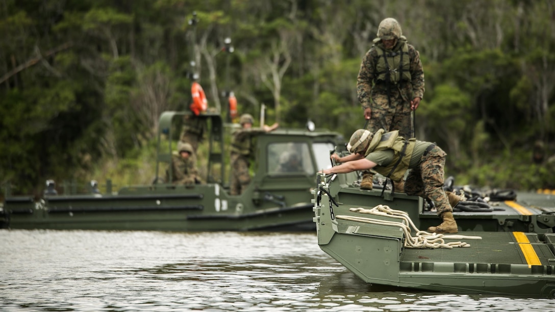 Marines work to complete a 15-bay Improved Ribbon Bridge in the Central Training Area, Okinawa, Japan, during Blue Chromite 2016, Nov. 2, 2015. This was the first time that Improved Ribbon Bridges, flat modular-floating platforms that bridge wet gaps, were inserted by air on Okinawa. Blue Chromite is a large-scale amphibious exercise that draws primarily from III Marine Expeditionary Force’s training resources on Okinawa. The location of the training allows participating units to maintain a forward-deployed posture and eliminates the cost of traveling to train. The Marines are with 9th Engineer Support Battalion, 3rd Marine Logistics Group, III Marine Expeditionary Force. (U.S. Marine Corps photo by Cpl. Drew Tech/Released)