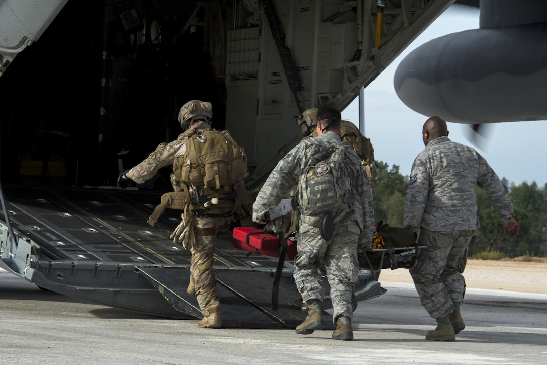 U.S. airmen carry a Portuguese air force pilot onto a C-130J Hercules aircraft during the rescue training part of Trident Juncture 2015 on Beja Air Base, Portugal, Oct. 23, 2015. U.S. Air Force photo by Airman 1st Class Luke Kitterman