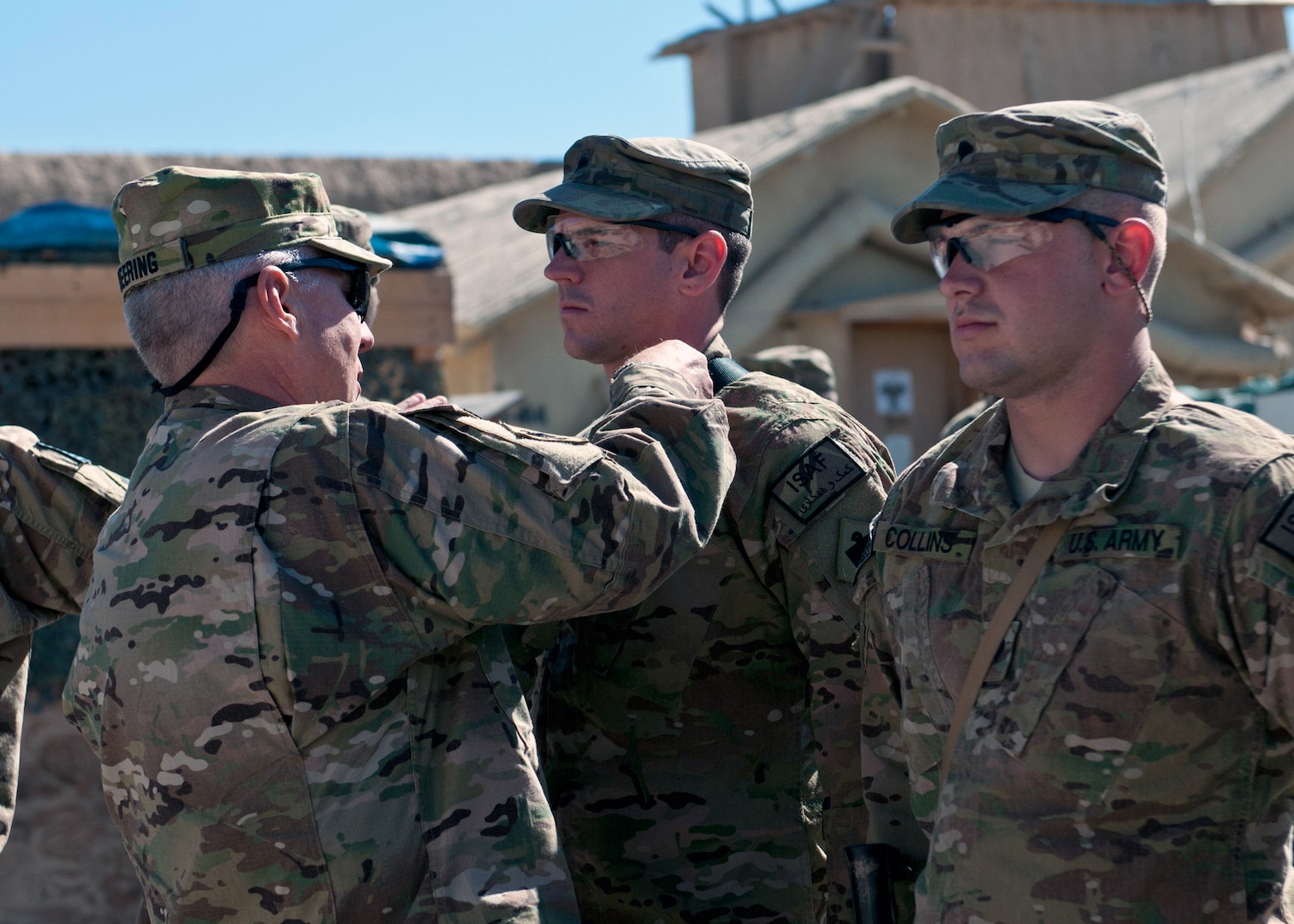 Army Maj. Gen. Myles Deering, adjutant general of Oklahoma, awards the Combat Infantry Badge to Army Spc. Jason Barrow, a member of Headquarters Company, 1st Battalion, 279th Infantry, 45th Infantry Brigade Combat Team during his visit Oct. 14, 2011.