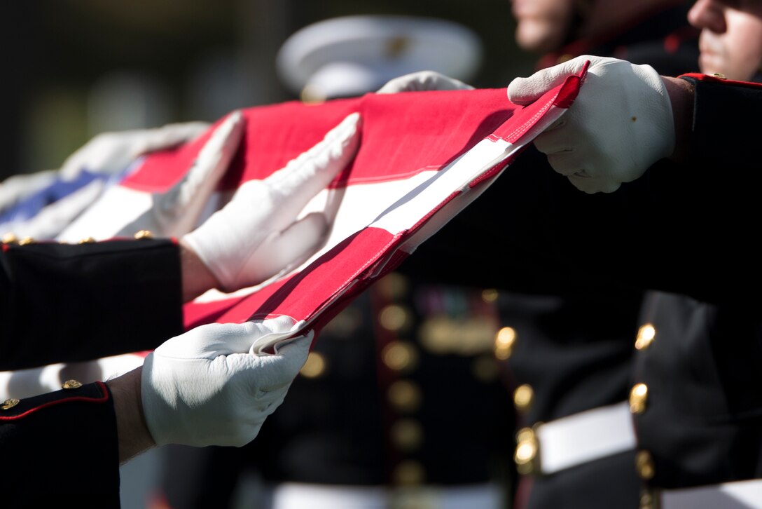 Body bearers from Company B, Marine Barracks Washington, D.C., conduct the flag folding ceremony during the full honors funeral of Lt. Gen. Frank E. Peterson Jr., retired, Oct. 30, 2015 at Arlington National Cemetery, Va. Petersen, the first African-American Marine Corps aviator and general, passed away Aug. 25, 2015. (U.S. Marine Corps Photo by Cpl. Chi Nguyen/Released)