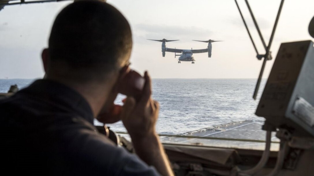 Senior Chief Culinary Specialist C. Wade Wilson, aircraft control officer aboard the amphibious dock landing ship USS Germantown (LSD 42), communicates with a MV-22 Osprey aircraft while landing on the flight deck aboard the ship during exercise Blue Chromite 16 off the coast of Okinawa, Japan, Oct. 28, 2015. BC 16 is a U.S. only exercise designed to increase amphibious proficiency between the Navy and Marine Corps.