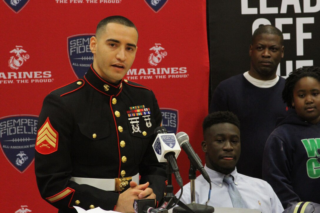 Sergeant Efarin Broutan, a canvassing recruiter for Marine Corps Recruiting Sub-Station Shreveport, speaks before presenting C.J. Morgan-Walker, a cornerback for Parkway High School in Bossier City, La., with a Semper Fidelis All-American Bowl game jersey on Oct. 23, 2015. The student athletes selected for the Semper Fidelis All-American Bowl are committed to their communities and exhibit leadership both on and off the field.