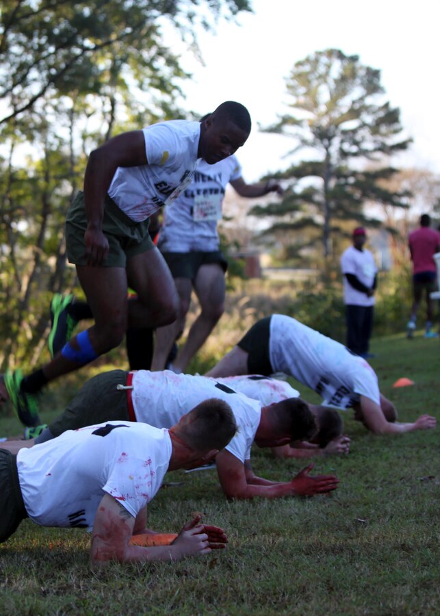 A team of competitors plank and perform exercises  during the annual Marine Special Operations Command All-Terrain Competition at Marine Corps Air Station Cherry Point, N.C., Oct. 30, 2015. Eleven teams of Marines and Sailors from the air station competed in the more than seven-mile competition. The first place winners were the Marine Aviation Logistics Squadron 14 Honey Badgers. (U.S. Marine Corps Photo by Lance Cpl. Jason Jimenez/Released)