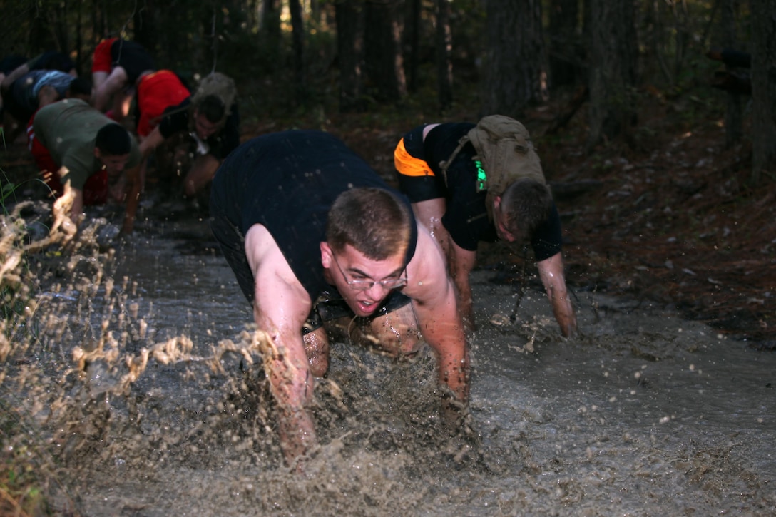 Competitors bear crawl through a mud pit during the annual Marine Special Operations Command All-Terrain Competition at Marine Corps Air Station Cherry Point, N.C., Oct. 30, 2015. Eleven teams of Marines and Sailors from the air station competed in the more than seven-mile competition. The first place winners were the Marine Aviation Logistics Squadron 14 Honey Badgers. (U.S. Marine Corps Photo by Lance Cpl. Jason Jimenez/Released)