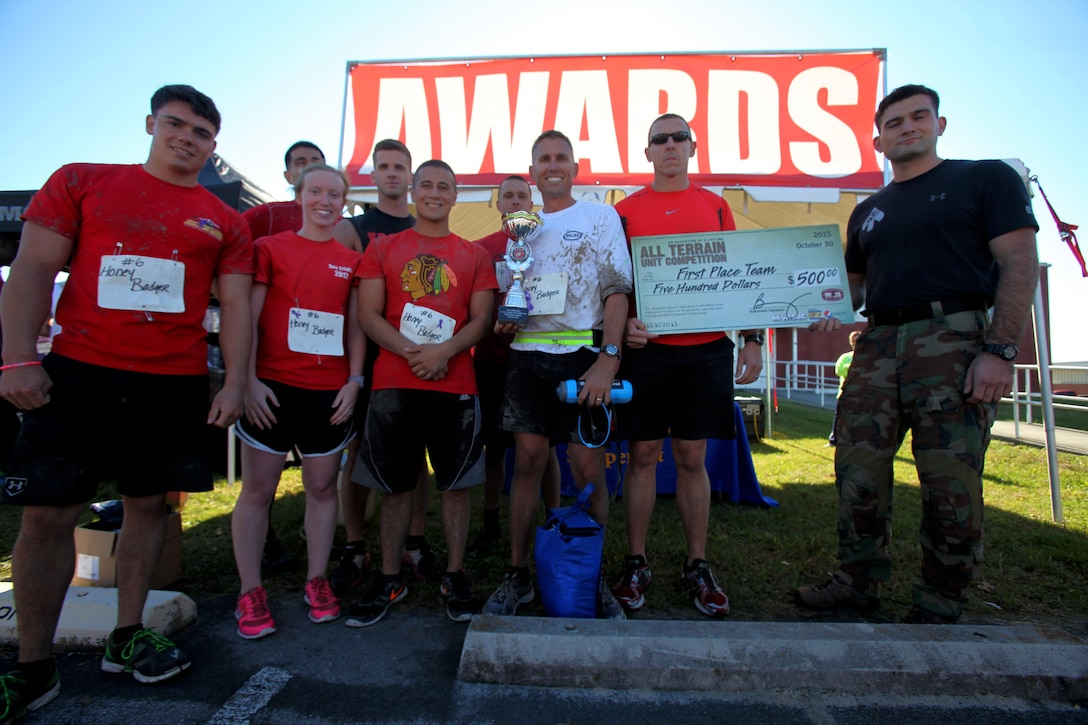 The Marine Aviation Logistics Squadron 14 Honey Badgers stand holding their trophy after being crowned 1st place winners during the annual Marine Special Operations Command All-Terrain Competition at Marine Corps Air Station Cherry Point, N.C., Oct. 30, 2015. Eleven teams of Marines and Sailors from the air station competed in the more than seven-mile competition. (U.S. Marine Corps Photo by Lance Cpl. Jason Jimenez/Released)