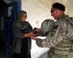 Army Lt. Col. Joel Jeffers, a civil affairs officer from the 4th Expeditionary Sustainment Command receives gifts from Fatima, a local business owner, Oct. 19, during a quality assurance visit with the Combined Team Zabul Female Engagement Team. Earlier in the month, the CTZ FET helped Fatima and Bibi Hawa obtain grants to open an almond and raisin-cleaning business in Qalat, Zabul province, Afghanistan.