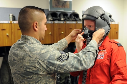 Air Force Staff Sgt. Luis Aguilar fits RAF Flight Lt. Kirsty Stewart with a helmet and oxygen mask in preparation for her F-16 orientation flight at the 162nd Fighter Wing at Tucson International Airport, Oct. 21, 2011. Stewart, a member of the United Kingdom's Red Arrows aerial demonstration team, was able to fly in the backseat of a Fighting Falcon with the international F-16 training wing.