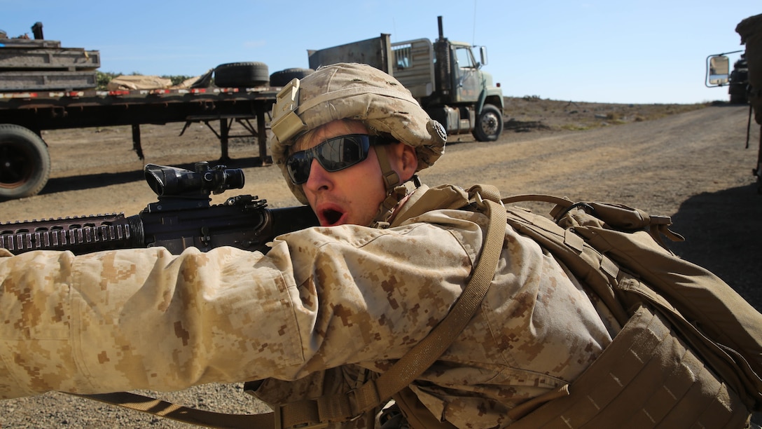 An infantryman with Assault Amphibian Vehicle Platoon, Company E, Battalion Landing Team 2/1, the ground combat element for the Boxer Amphibious Ready Group and 13th Marine Expeditionary Unit, fires from behind cover as an Assault Amphibian Vehicle moves into position to provide supporting fire during amphibious assault training as part of Composite Training Unit Exercise, Oct. 23, 2015. COMPTUEX provides the MEU ARG the opportunity to integrate naval training while also allowing focused, mission-specific training and evaluation for the Navy-Marine Corps team. 