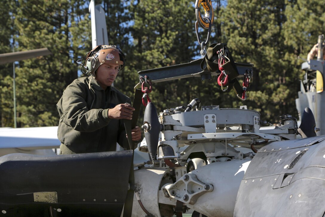 Marine Corps Cpl. Gustavo Ordinola secures the hub sling to a prop rotor hub to be reinstalled on an MV-22B Osprey aircraft during Mountain Exercise 6-15 at Mountain West Aviation, South Lake Tahoe, Calif., Oct. 26, 2015. Ordinola is a mechanic assigned to Marine Medium Tiltrotor Squadron 163, Marine Aircraft Group 16, 3rd Marine Aircraft Wing. U.S. Marine Corps photo by Cpl. Allison J. Herman