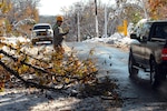Army National Guard Spc. Seth Tuper, a combat engineer, 379th Engineer Company, 101st Engineer Battalion, Massachusetts Army National Guard, directs traffic around a tree that had fallen on Springfield Street in Wilbraham, Mass., blocking half the road and creating a potential traffic hazard on Oct. 30, 2011. As Tuper, a resident of Florida, Mass., directed traffic, other Soldiers from his unit used chain saws to quickly cut down the tree.