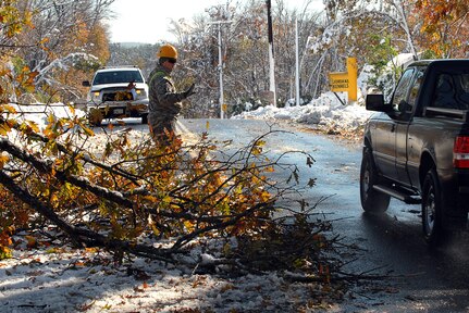 Army National Guard Spc. Seth Tuper, a combat engineer, 379th Engineer Company, 101st Engineer Battalion, Massachusetts Army National Guard, directs traffic around a tree that had fallen on Springfield Street in Wilbraham, Mass., blocking half the road and creating a potential traffic hazard on Oct. 30, 2011. As Tuper, a resident of Florida, Mass., directed traffic, other Soldiers from his unit used chain saws to quickly cut down the tree.