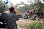 Members of the Joint Counterdrug Task Force conduct a house demolition in Harlingen, Texas, Aug. 31, 2011. The city government-ordered demolition was part of a daylong program, called Operation Crackdown that was developed to clean up neighborhoods by eliminating drug havens. The program is a part of the task force's community outreach effort designed to reduce illicit activities through the anti-drug message.