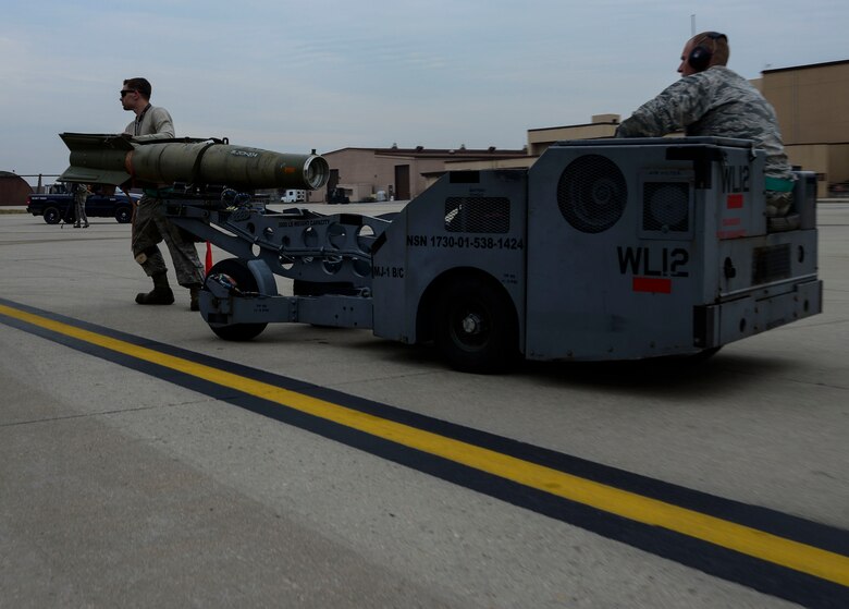 Staff Sgt. Christopher Uecker and Senior Airman Nathan Smith, 25th Aircraft Maintenance Unit weapons load crew team members, drive a guided bomb unit to be loaded onto an A-10 Thunderbolt II during the Vigilant Ace 16 exercise on Osan Air Base, Republic of Korea, Nov. 1, 2015. The weapons section of the 25th AMU is responsible for the maintenance and loading of various missiles, pylons, and other armament systems onto the A-10 fleet. (U.S. Air Force photo/Senior Airman Kristin High)