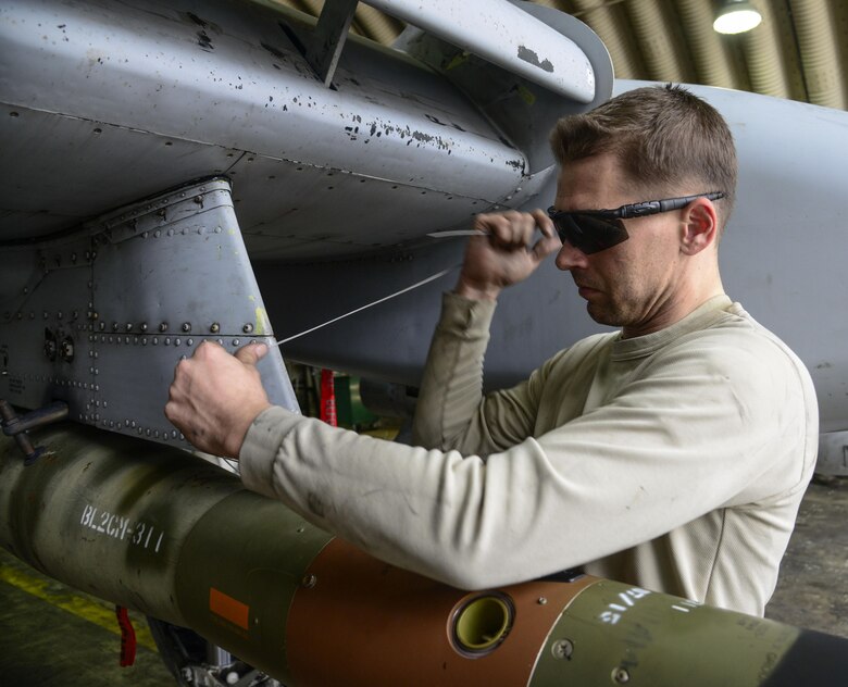 Staff Sgt. Christopher Uecker, 25th Aircraft Maintenance Unit weapons load crew team chief, tightens arming wire on an A-10 Thunderbolt II during the Vigilant Ace 16 exercise on Osan Air Base, Republic of Korea, Nov. 1, 2015. The arming wire holds the guided bomb unit in place until proper aerial release. (U.S. Air Force photo/Senior Airman Kristin High)