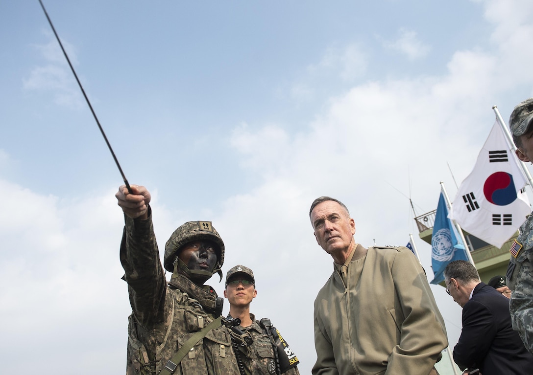 U.S. Marine Corps Gen. Joseph F. Dunford Jr., chairman of the Joint Chiefs of Staff, listens to a South Korean soldier as he points to a scene during a trip to the Demilitarized Zone in South Korea, Nov. 2, 2015. DoD photo by U.S. Navy Petty Officer 2nd Class Dominique A. Pineiro