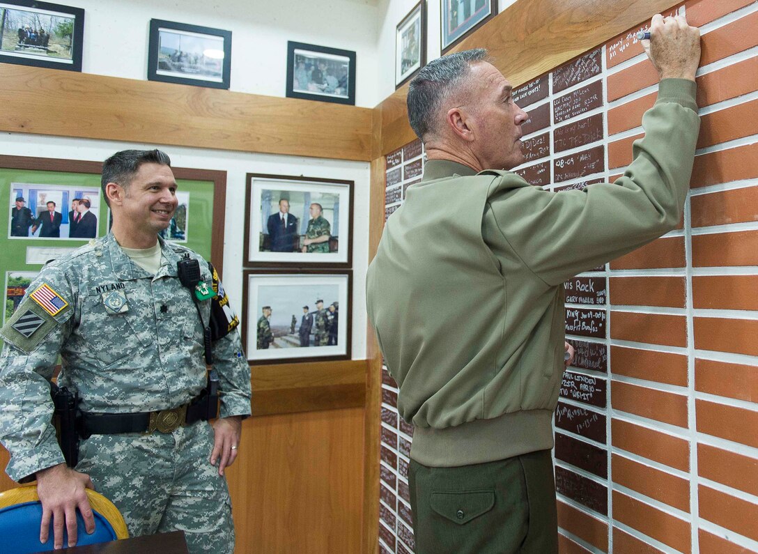 U.S. Marine Corps Gen. Joseph F. Dunford Jr., chairman of the Joint Chiefs of Staff, signs a wall in the dining facility on Camp Bonifas after having lunch with U.S. and South Korean troops during a trip to the Demilitarized Zone in South Korea, Nov. 2, 2015. DoD photo by U.S. Navy Petty Officer 2nd Class Dominique A. Pineiro