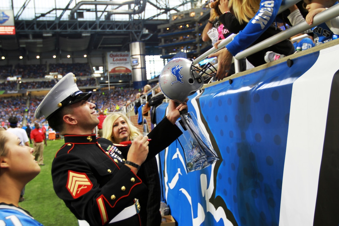 U.S. Marine Sgt. Benjamin J. Annarino signs a fan’s helmet during a Detroit Lions football game at Ford Field in Detroit, Oct. 20, 2015. Annarino was honored as the game’s Hometown Hero during a break in play in the third quarter. Annarino is a canvassing recruiter for Recruiting Station Detroit and a Livonia, Mich., native. U.S. Marine Corps photo by Sgt. J. R. Heins