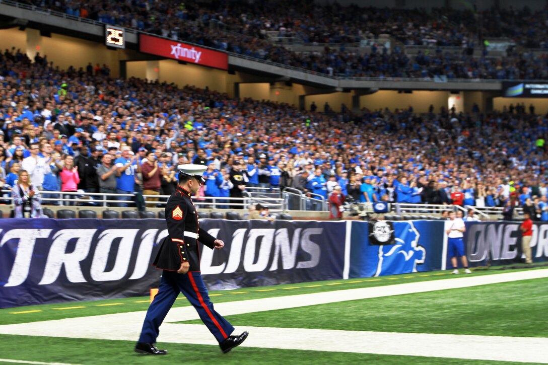 U.S. Marine Sgt. Benjamin J. Annarino walks onto the field as more than 60,000 fans cheer during a Detroit Lions football game at Ford Field in Detroit, Oct. 20, 2015. Annarino was honored as the game’s hometown hero during a break in play in the third quarter. Annarino is a canvassing recruiter for Recruiting Station Detroit and a Livonia, Michigan, native. U.S. Marine Corps photo by Sgt. J. R. Heins