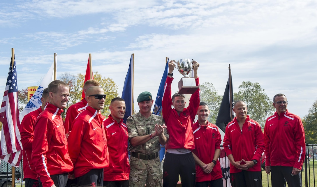 U.S. Marine Corps Running Team claims the Challenge Cup Competition trophy from their running counterparts of the Royal Navy/Marines after finishing the 40th Marine Corps Marathon, during the Armed Forces Award ceremony, Arlington, Va., Oct. 25, 2015. Also known as "The People's Marathon," the 26.2-mile race drew roughly 30,000 participants to promote physical fitness, generate goodwill in the community, and showcase the organizational skills of the Marine Corps. (U.S. Marine Corps photo by Kathy Reesey/Released)