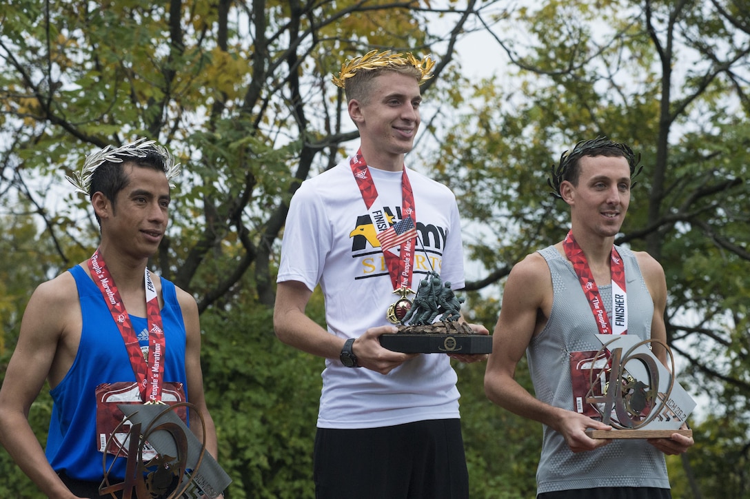 The top 3 finishers of the 40th Marine Corps Marathon (MCM), 1st place winner U.S. Army Lt. Trevor Lafontaine (center), from Cornwall, N.Y., 2nd place winner Oscar Mateo (left), of Mexico, and 3rd place winner Brian Flynn (right) of Rockingham, Va., pose for a photo after being crowned the winners of the 40th MCM at the award ceremony in Arlington, Va., Oct. 25, 2015. Also known as "The People's Marathon," the 26.2 mile race drew roughly 30,000 participants to promote physical fitness, generate goodwill in the community, and showcase the organizational skills of the Marine Corps. (U.S. Marine Corps photo by Staff Sgt. Sarah R. Hickory/Released)